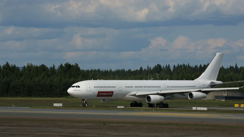 OSLO AIRPORT - JULY 2013: Huge Airbus A340 hold for takeoff. A small Cessna land