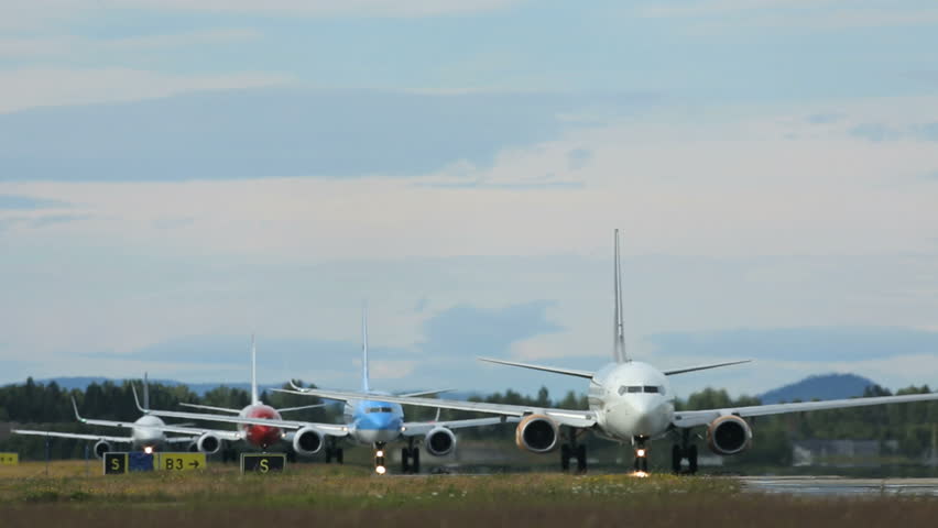 OSLO AIRPORT - JULY 18 2013: Line of airplanes taxi for takeoff at OSL airport