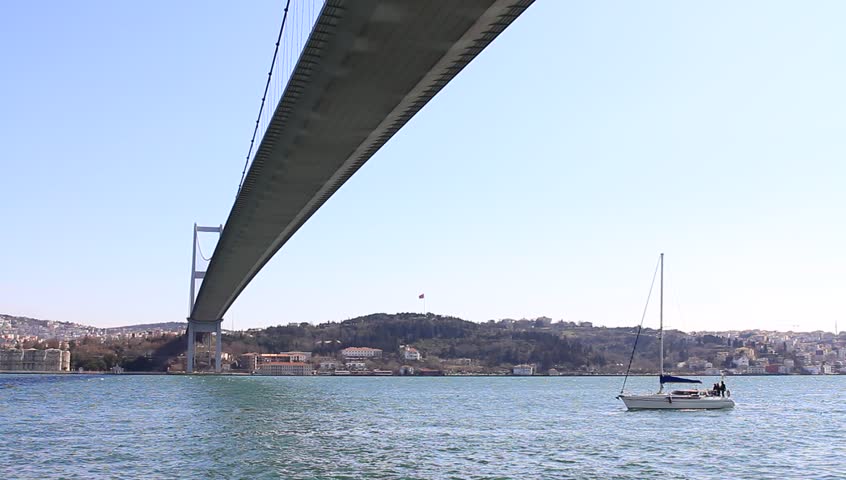 Yacht sailing under Bosporus Bridge in Istanbul