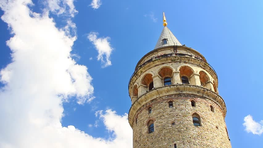 Galata Tower against fast white clouds. Timelapse

