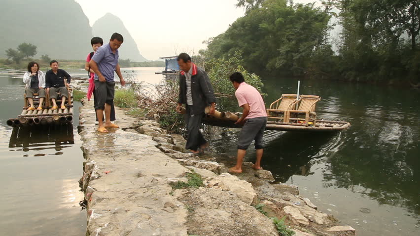 YANGSHUO, GUANGXI, CHINA - OCTOBER 21: Bamboo raft drivers drag bamboo rafts up