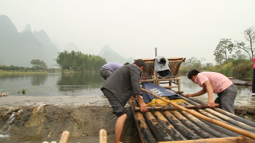 YANGSHUO, GUANGXI, CHINA - OCTOBER 21: Bamboo raft drivers drag bamboo rafts up