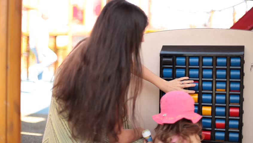 Mother and daughter playing rolls game in park.

