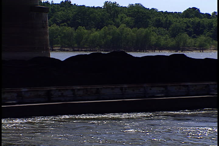 Pushboat drives coal barge under railroad bridge and up the Ohio River in Metropolis, Illinois.
