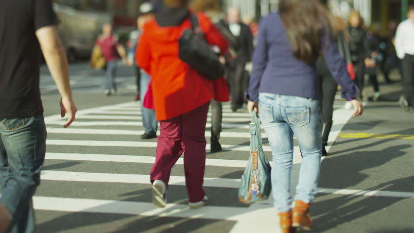 Anonymous crowd of people crossing on a busy New York city street. In slow motion.