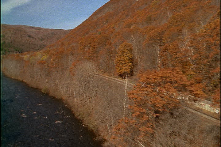 Freight train moves past the woods along the Deerfield River in North Adams, Massachusetts.