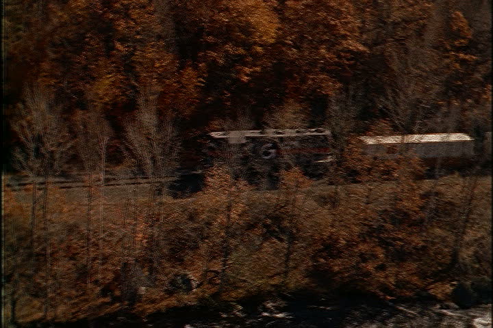 Freight train moves past woods along the Deerfield River in North Adams, Massachusetts.