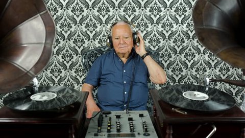 a very funky elderly grandpa dj mixing records with gramophones
