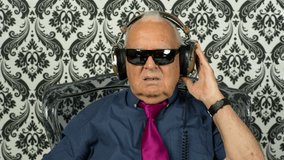 a very funky elderly grandpa dj listening to music on headphones
