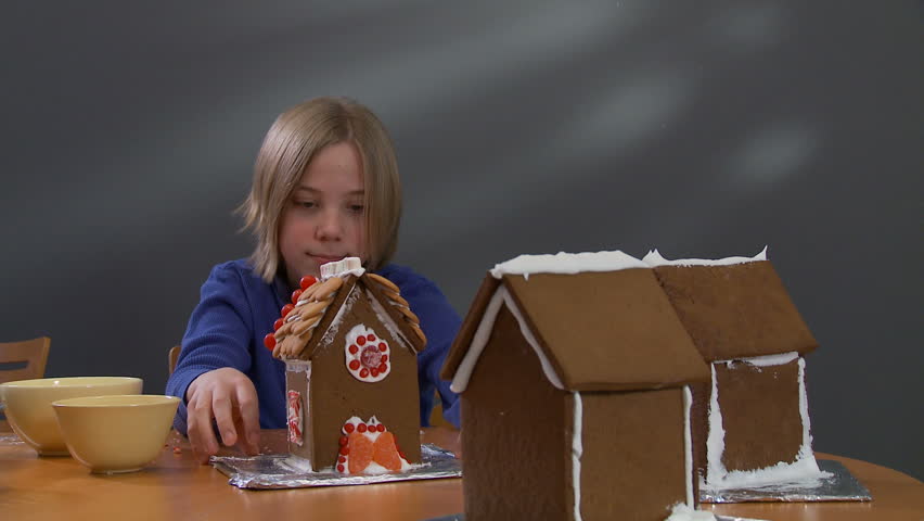 Boy shows his finished gingerbread house.