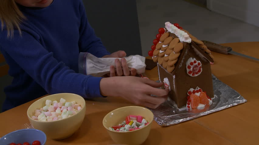 Sticking a window on a gingerbread house.