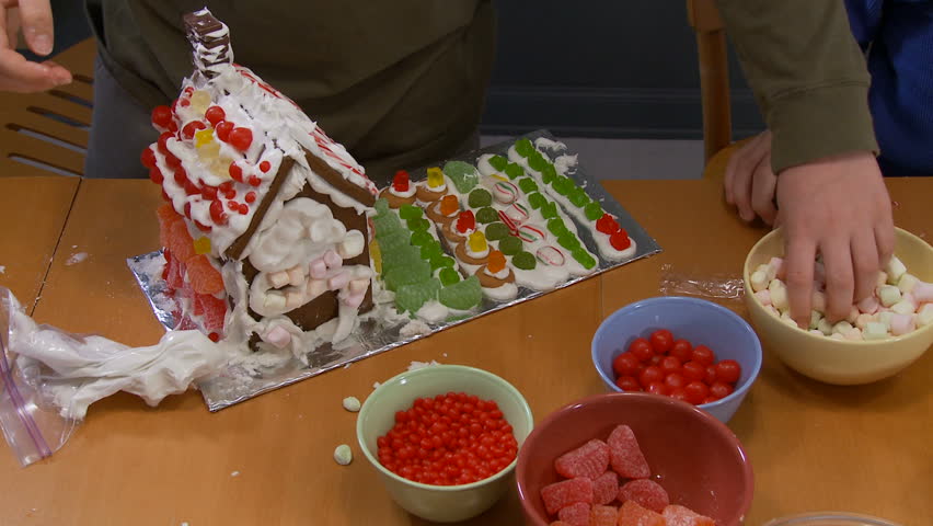 Sticking candies on a gingerbread house.