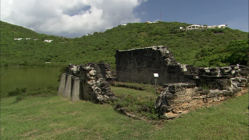 Luxury modern villas overlook crumbling ruins near a river in Guana