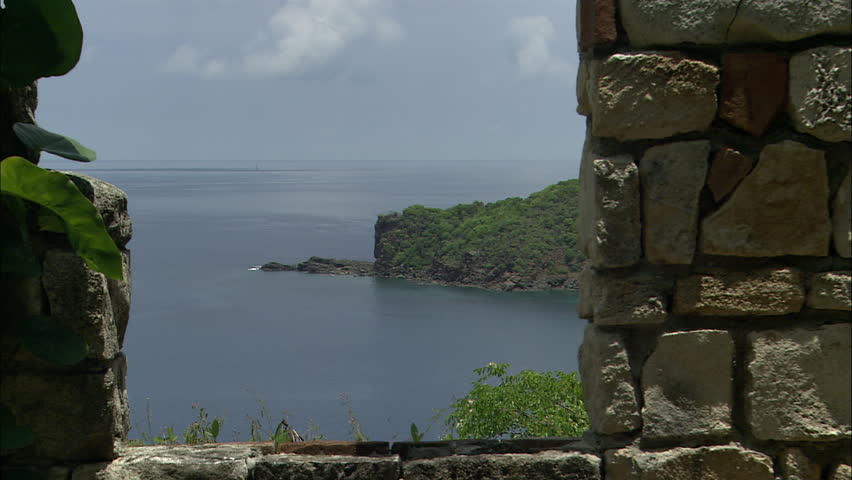 View of a scenic forest peninsula through the window of stone ruins