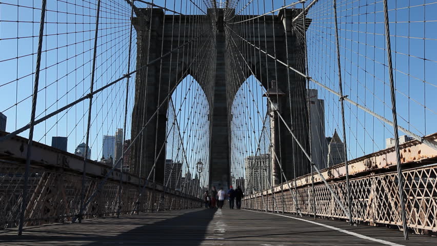 NEW YORK - MARCH 2: pedestrians walking on the Brooklyn Bridge on a sunny winter