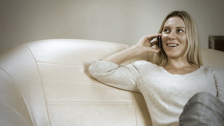 Beautiful girl on sofa speaking by phone