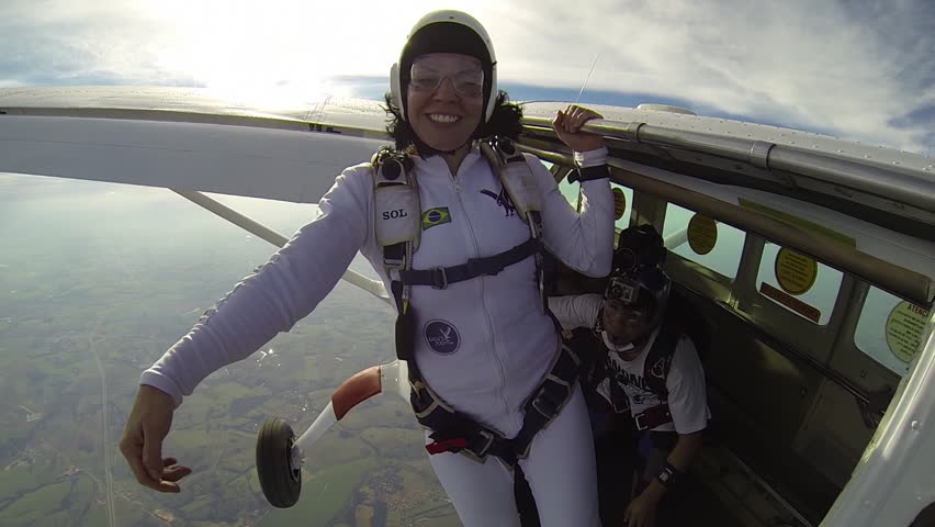 Skydiver woman freestyle in white clothes at sunny day, freedom concept.