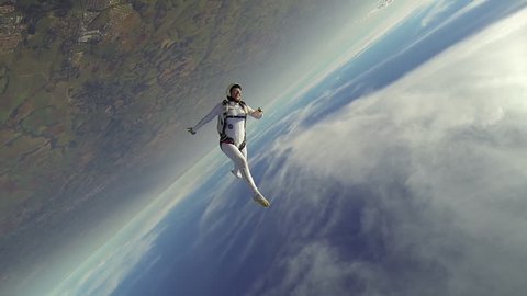 Skydiver woman freestyle in white clothes at sunny day, freedom concept.