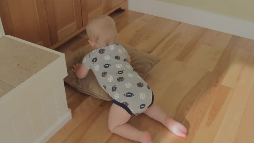 A baby boy playing in his house.