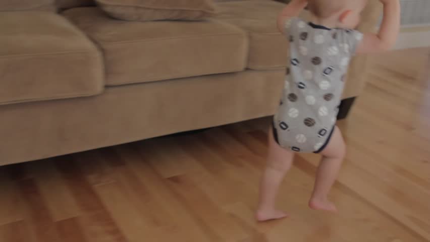 A baby boy playing in his house.