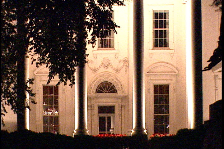 MS of the entrance at the White House North Portico at night flanked by silhouette of trees in Washington, D.C..
