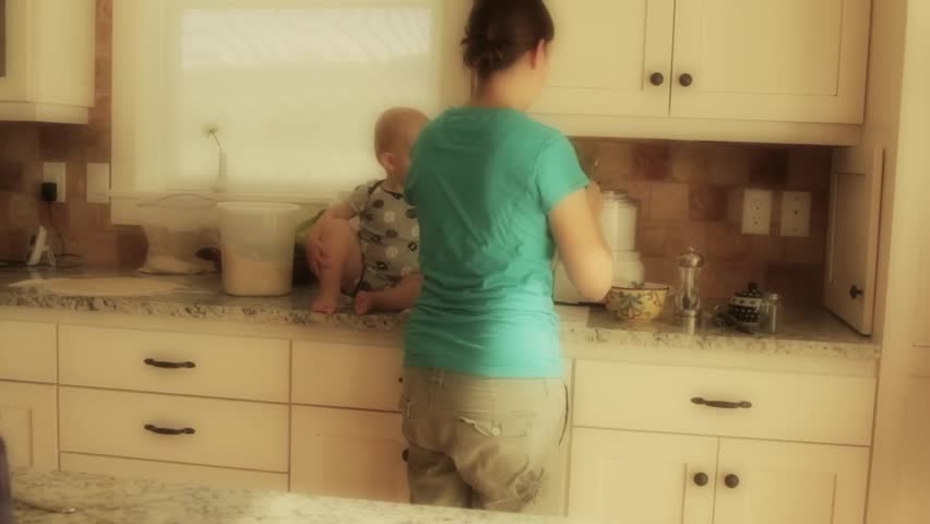 A mother with her baby boy while cooking in the kitchen