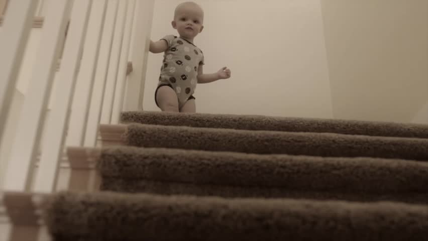 A little boy playing on the stairs with his mother