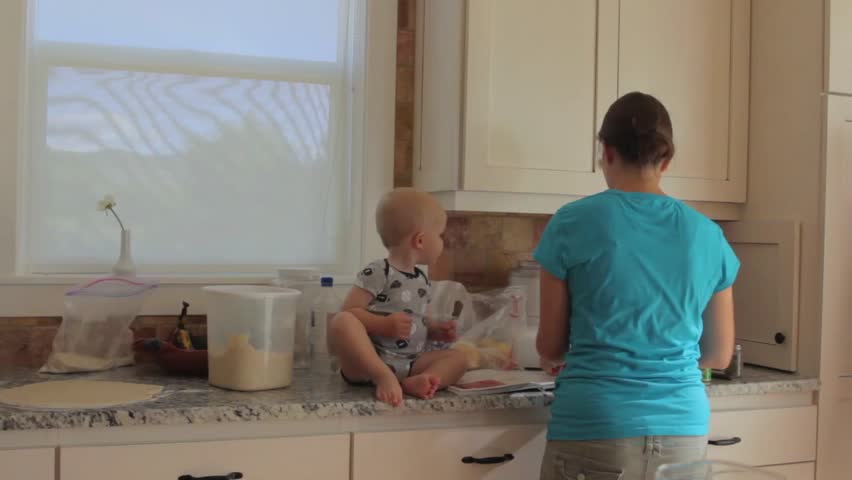 A mother with her baby boy while cooking in the kitchen