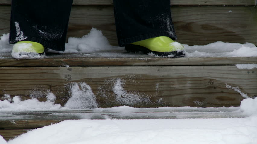 Close view of clearing snow from wooden steps.