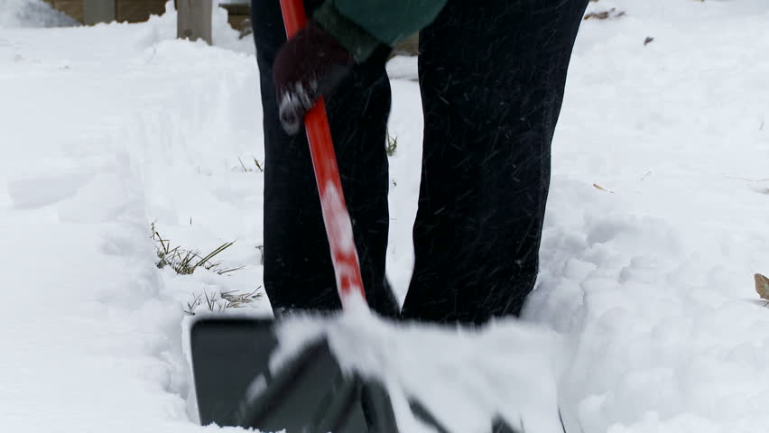 Clearing a path in the snow with a shovel.