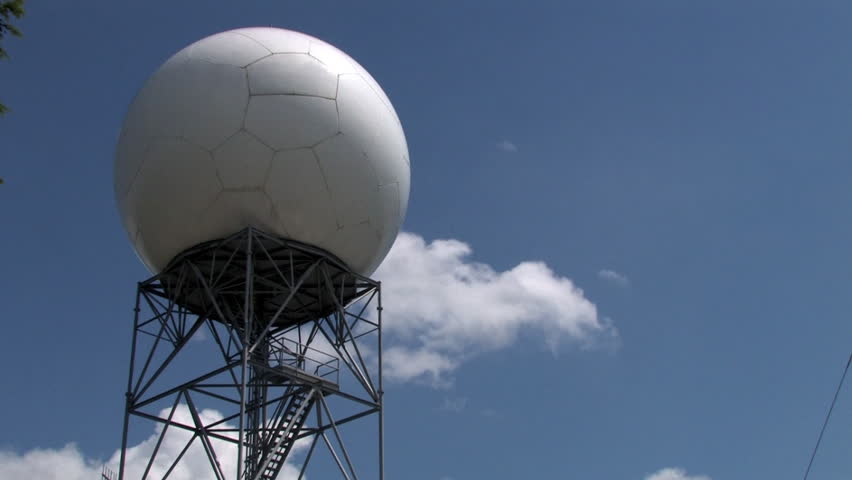 A time-lapse shot of clouds traveling behind a doppler radar dome.