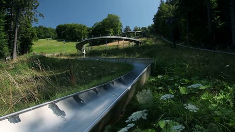 Children driving with bobsled in beautiful surroundings