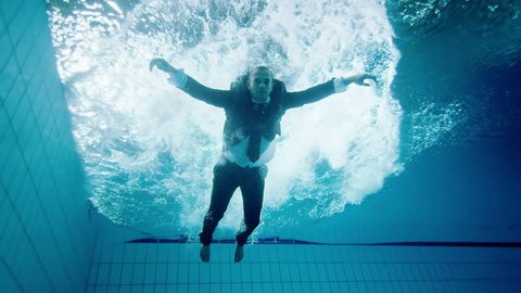 Drowning underwater businessman, falls into the water and remains motionless and unable to help himself. Video Stok