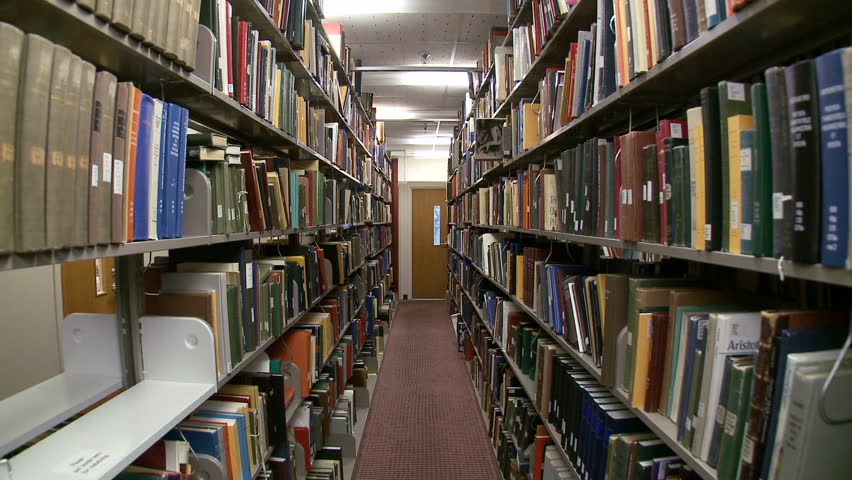 Wide angle view of man browsing for books in library.