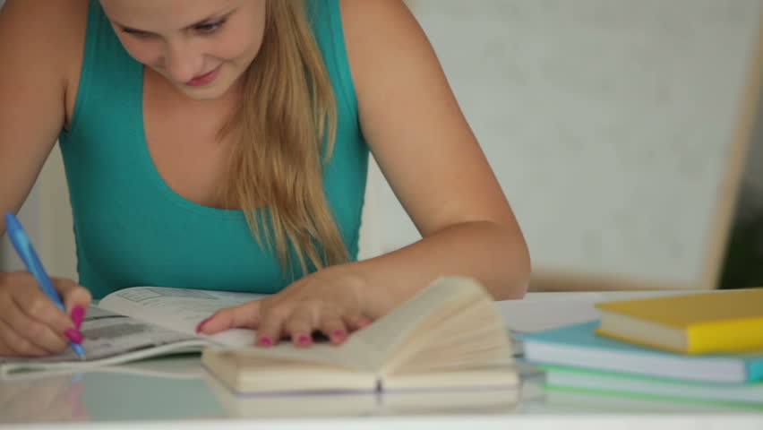 Happy girl writing in notebook and smiling close up