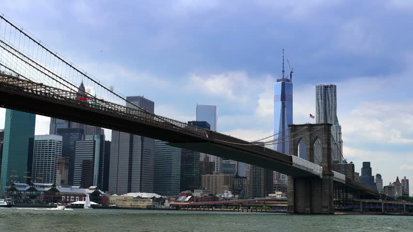A dramatic time lapse of the New York City skyline behind the Brooklyn Bridge. 