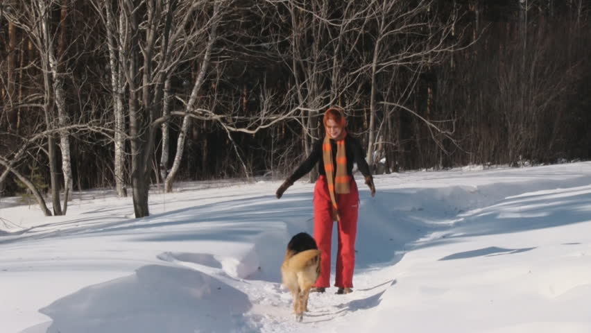 Woman playing with a dog on a snow