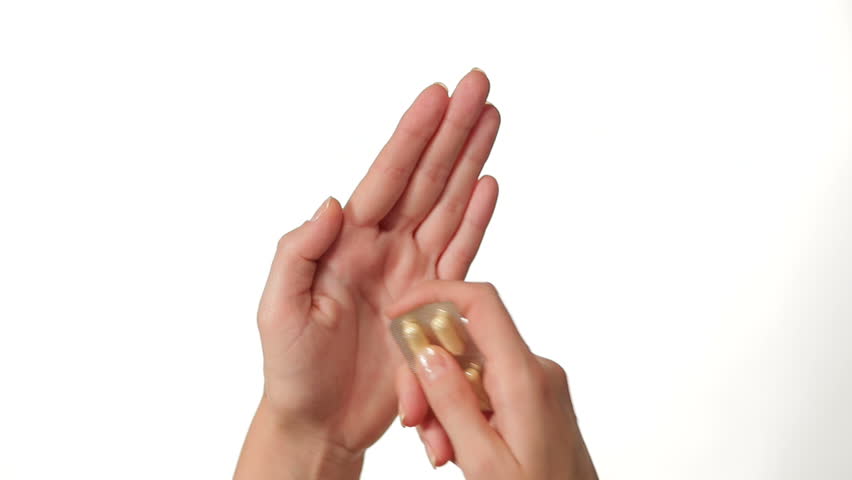 Hands Pressing Pill out of Blister Package