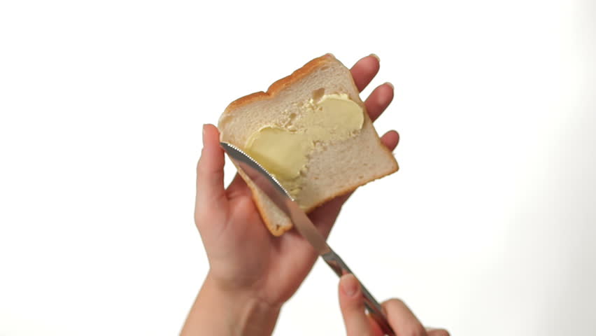 Hand Buttering a Slice of Toast on white background
