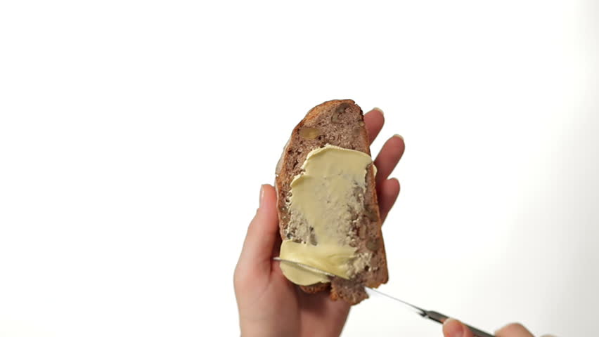 Hand Buttering a Slice of Bread on white background