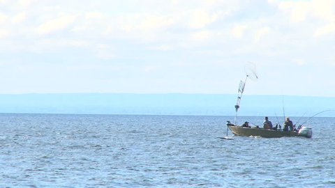 Fishermen trolling for fish on Lake Superior in small boat.