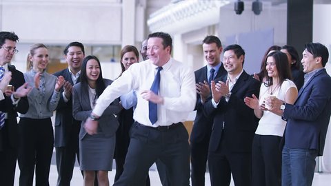 Funny dancing businessman. Excited group of business people clap their strange colleague.