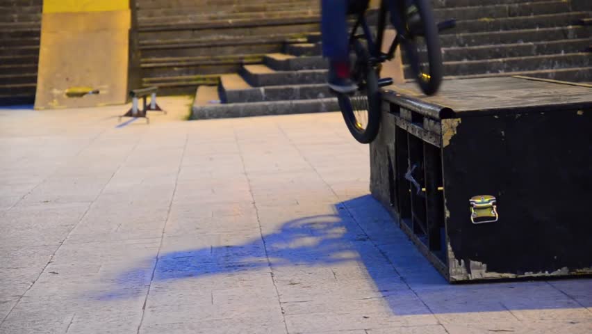 bicycle driver slide on edge of ledge box. BMXer sliding a edge of a ledge ramp