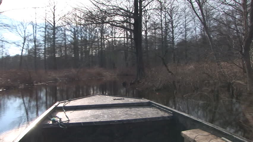 Boat traveling waterway in Bayou swamp while duck hunting