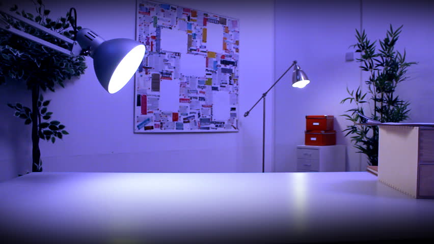 Person at work during the evening under desk lamp looking suspicious. High quality HD video footage