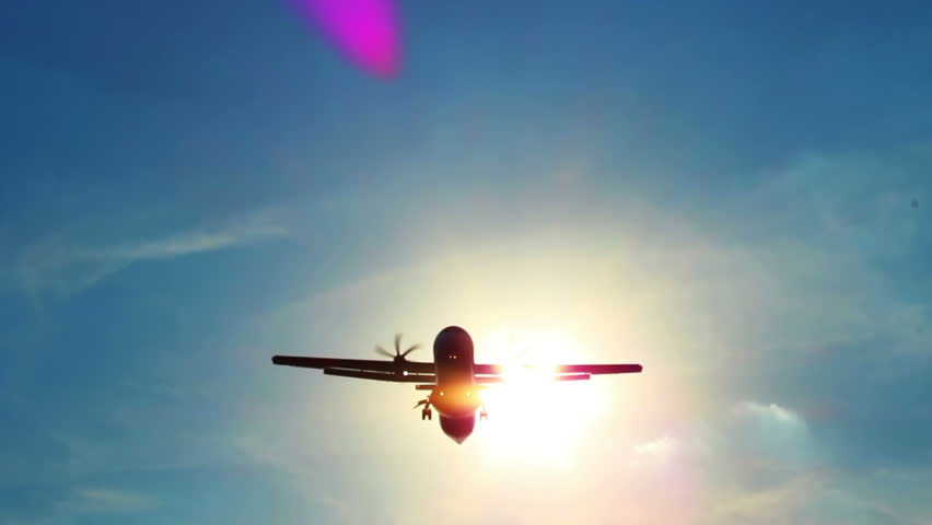 Airplane flies through sun leaving ray traces above