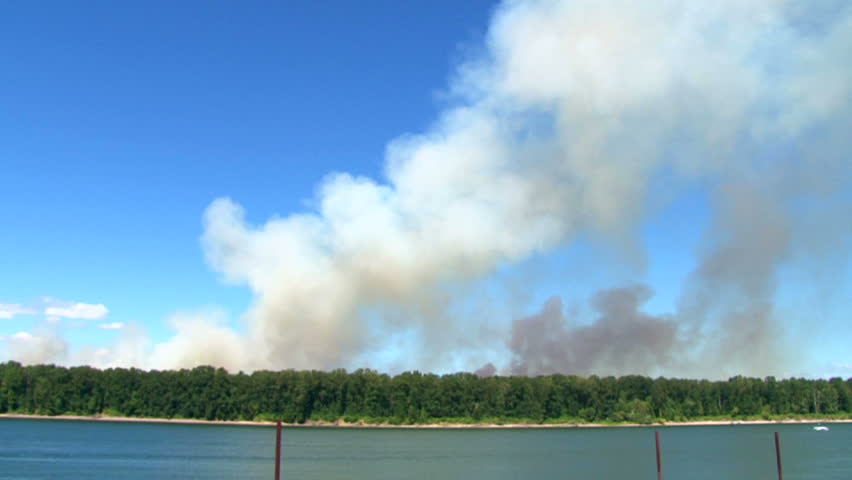 Forest fire burns wild on Government Island in Oregon on windy day, time lapse.