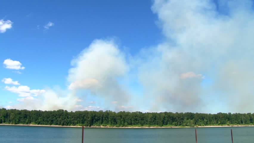 Forest fire burns wild on Government Island in Oregon on windy day, time lapse.