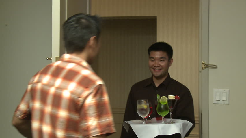 Waiter brings room service drinks and gets a tip.