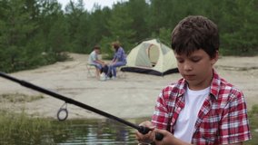 Close-up of a serious boy learning how to use a fishing rod